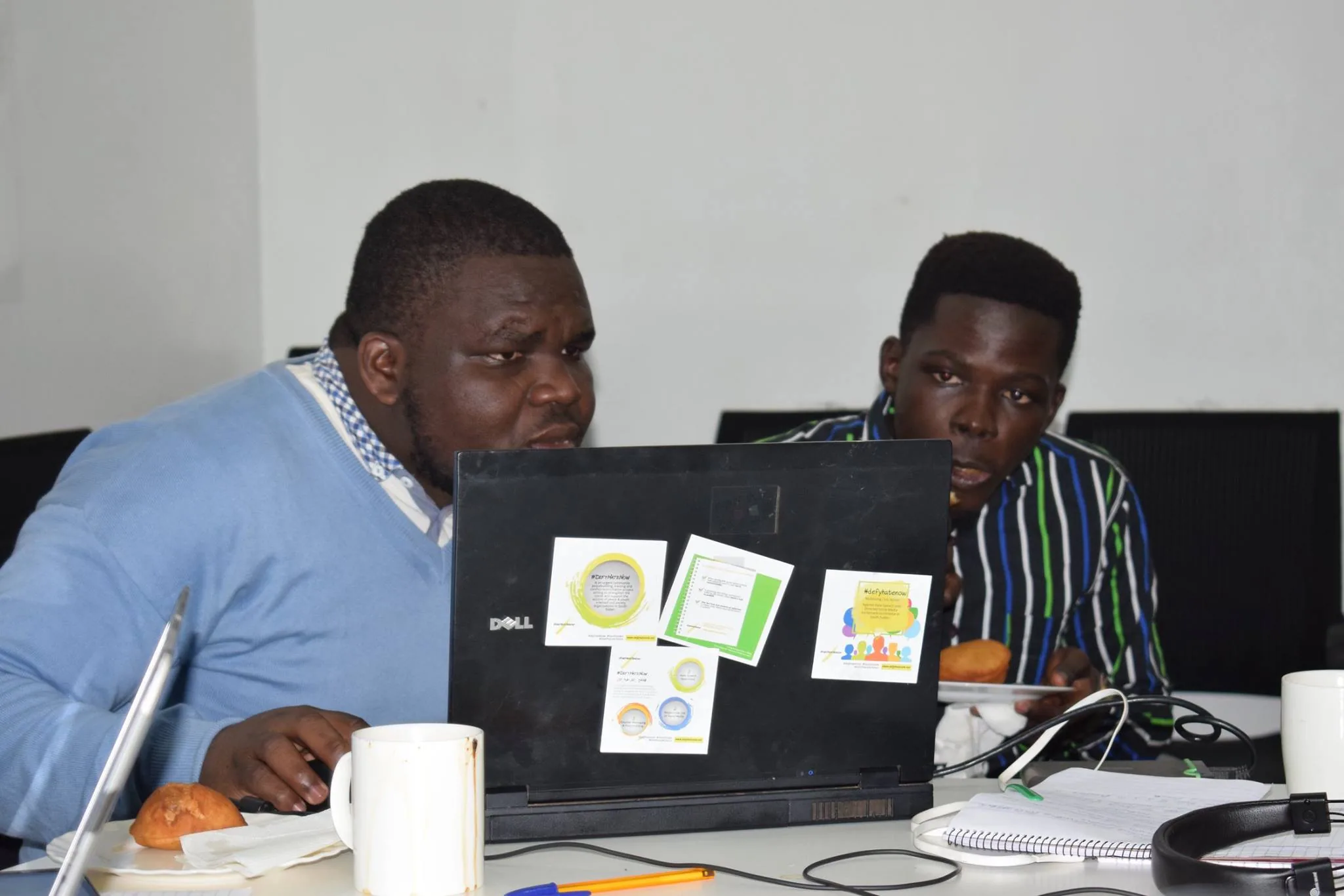 Two colleagues reviewing work on a laptop